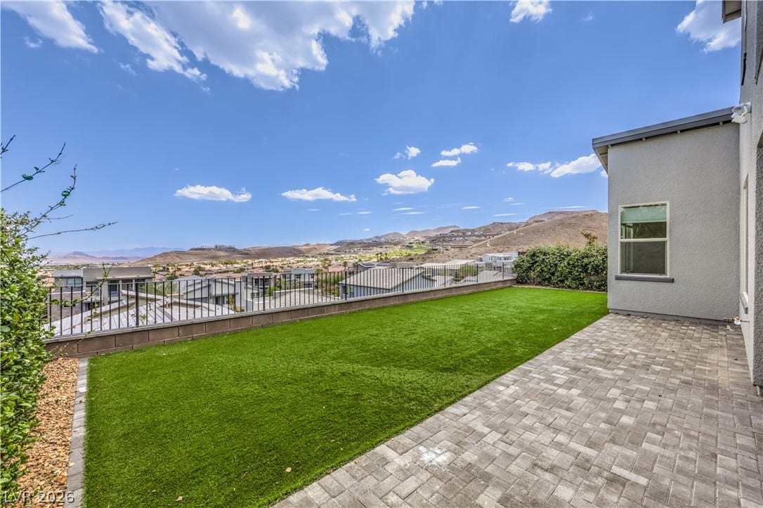 1984 Canyon Highlands Drive, Henderson, NV 89052 A spacious backyard with artificial turf and paver patio offers panoramic hillside and neighborhood views.