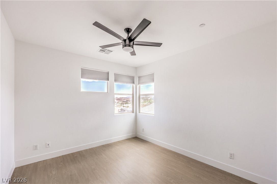 1984 Canyon Highlands Drive, Henderson, NV 89052 A quiet bedroom with light-toned flooring and multiple windows, providing elevated views.