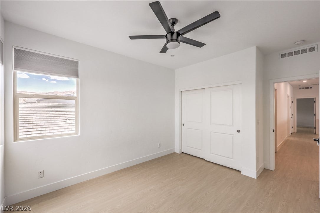 1984 Canyon Highlands Drive, Henderson, NV 89052 A quiet bedroom featuring light wood flooring, a window with views, and a contemporary ceiling fan for comfort.