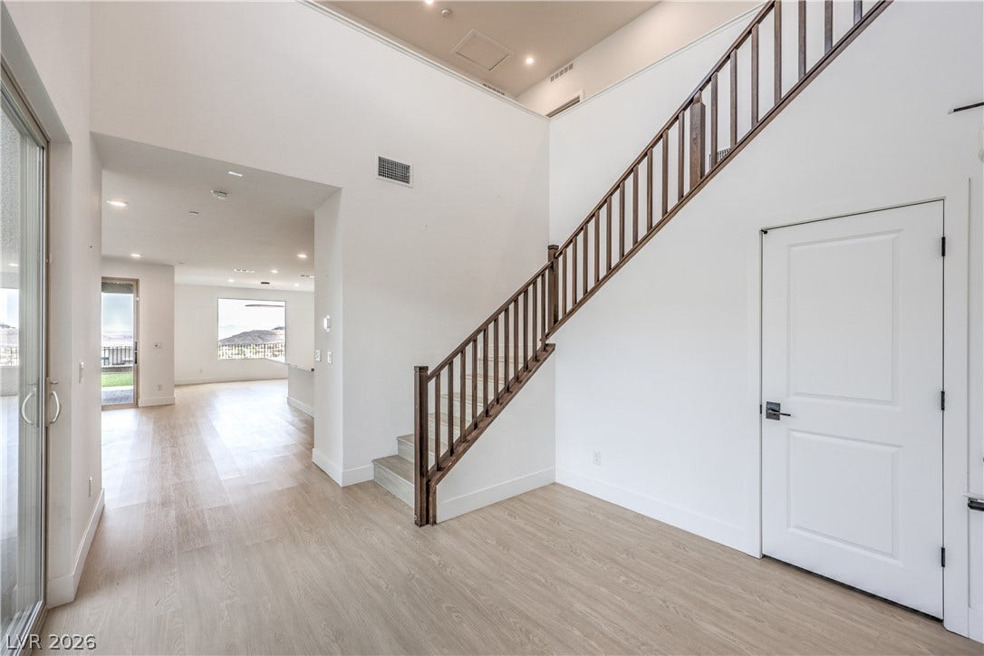 1984 Canyon Highlands Drive, Henderson, NV 89052 A spacious entry area boasts lofty ceilings and light wood flooring, leading to an elegant wooden staircase.