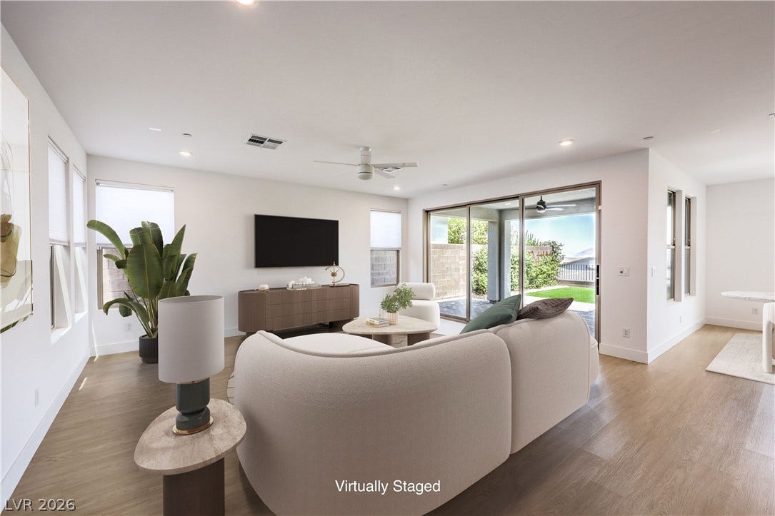 1984 Canyon Highlands Drive, Henderson, NV 89052 Natural light streams into this generously proportioned living area, featuring sleek wood flooring and a refreshing ceiling fan.