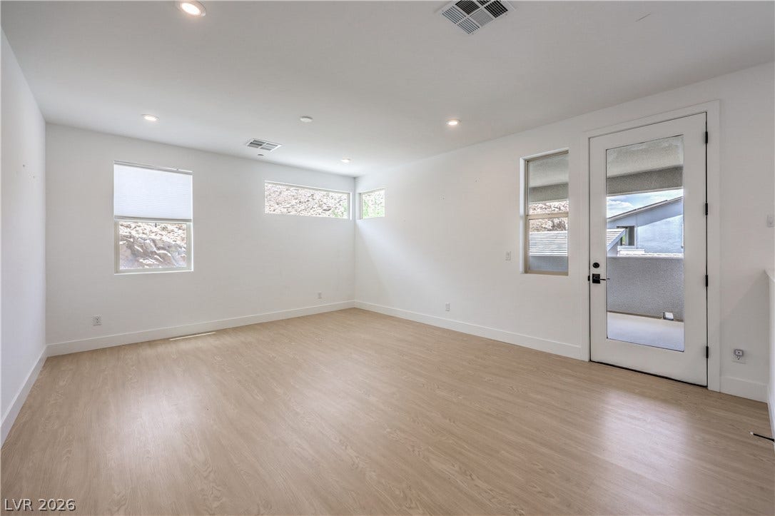1984 Canyon Highlands Drive, Henderson, NV 89052 Recessed lighting illuminates this bright, empty room featuring modern flooring and access to a private outdoor space.