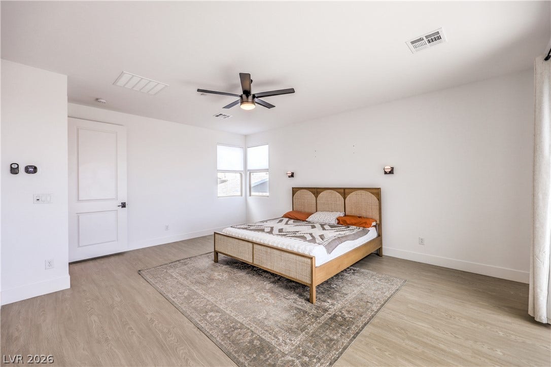 1984 Canyon Highlands Drive, Henderson, NV 89052 A well-lit bedroom features durable laminate flooring and a ceiling fan for comfort.