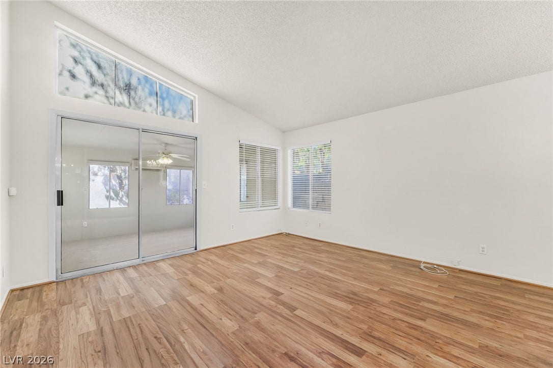 62 Tidwell Lane, Henderson, NV 89074 High vaulted ceilings and rich wood-style flooring ground this versatile, sunlit living area.