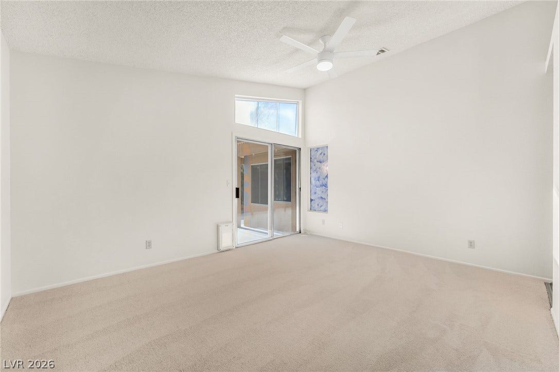 62 Tidwell Lane, Henderson, NV 89074 Sliding glass doors open to the patio from this carpeted living area with vaulted ceilings.