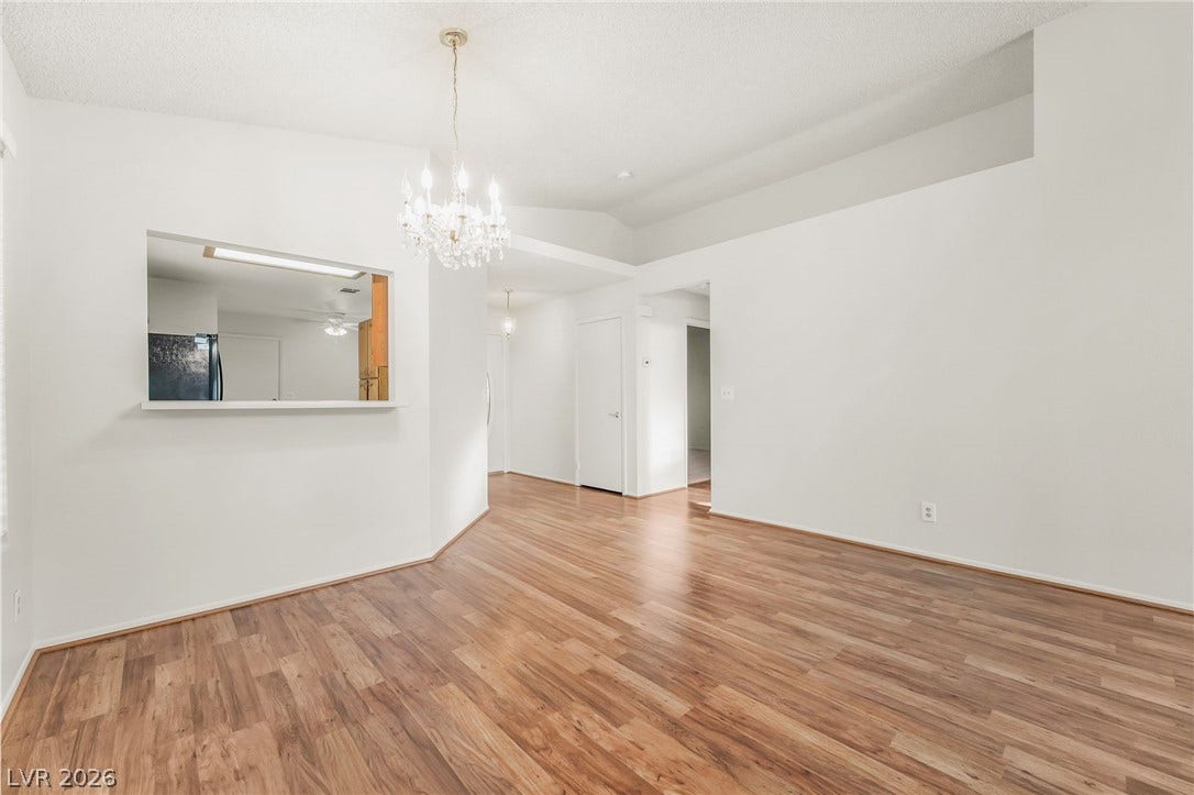 62 Tidwell Lane, Henderson, NV 89074 Rich wood-inspired flooring pairs with a classic chandelier under vaulted architectural lines.