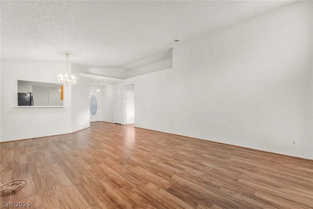 62 Tidwell Lane, Henderson, NV 89074 Rich wood floors and clean white walls anchor this versatile open-plan interior layout.