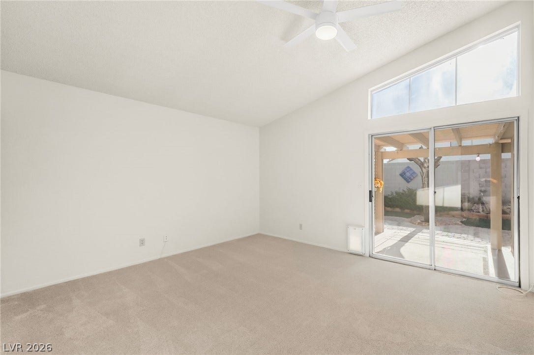 62 Tidwell Lane, Henderson, NV 89074 Sliding glass doors beneath a clerestory window frame views of the rear patio.