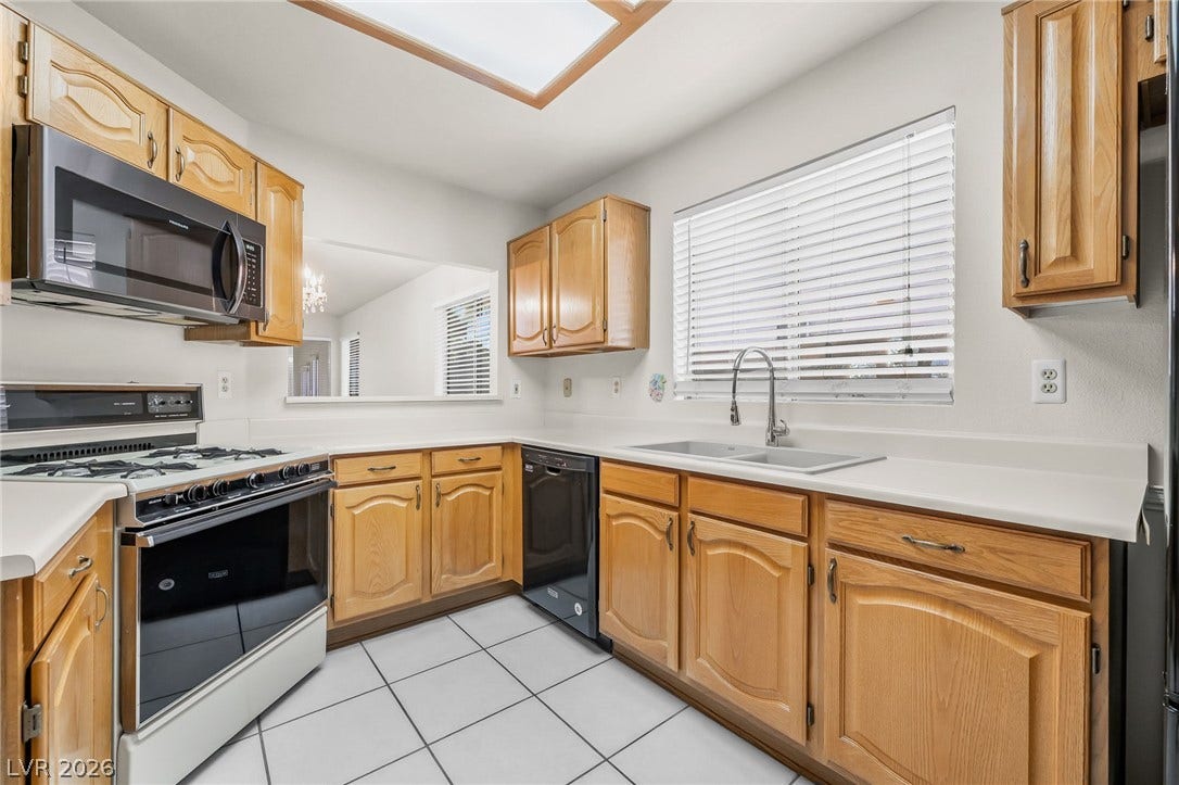 62 Tidwell Lane, Henderson, NV 89074 Ample wooden cabinetry and ceramic tile flooring define this functional kitchen space.