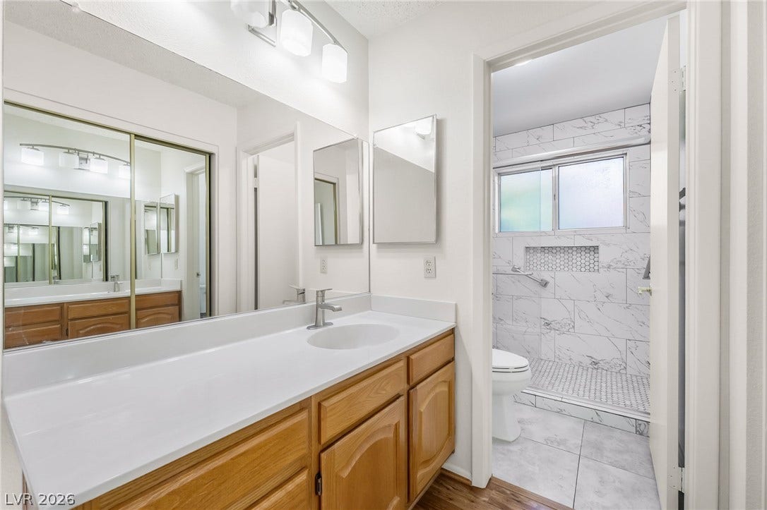 62 Tidwell Lane, Henderson, NV 89074 Clean countertops and wood cabinetry define this functional split layout bathroom.