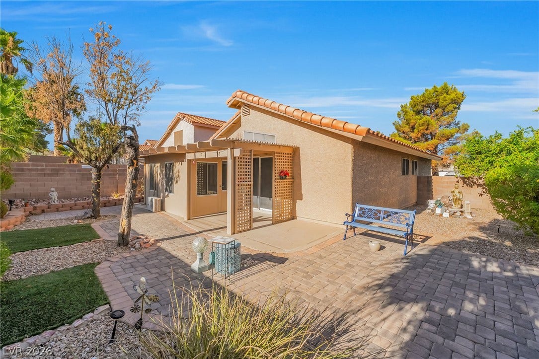 62 Tidwell Lane, Henderson, NV 89074 An inviting paved patio area extends from the stucco exterior under clear blue skies.