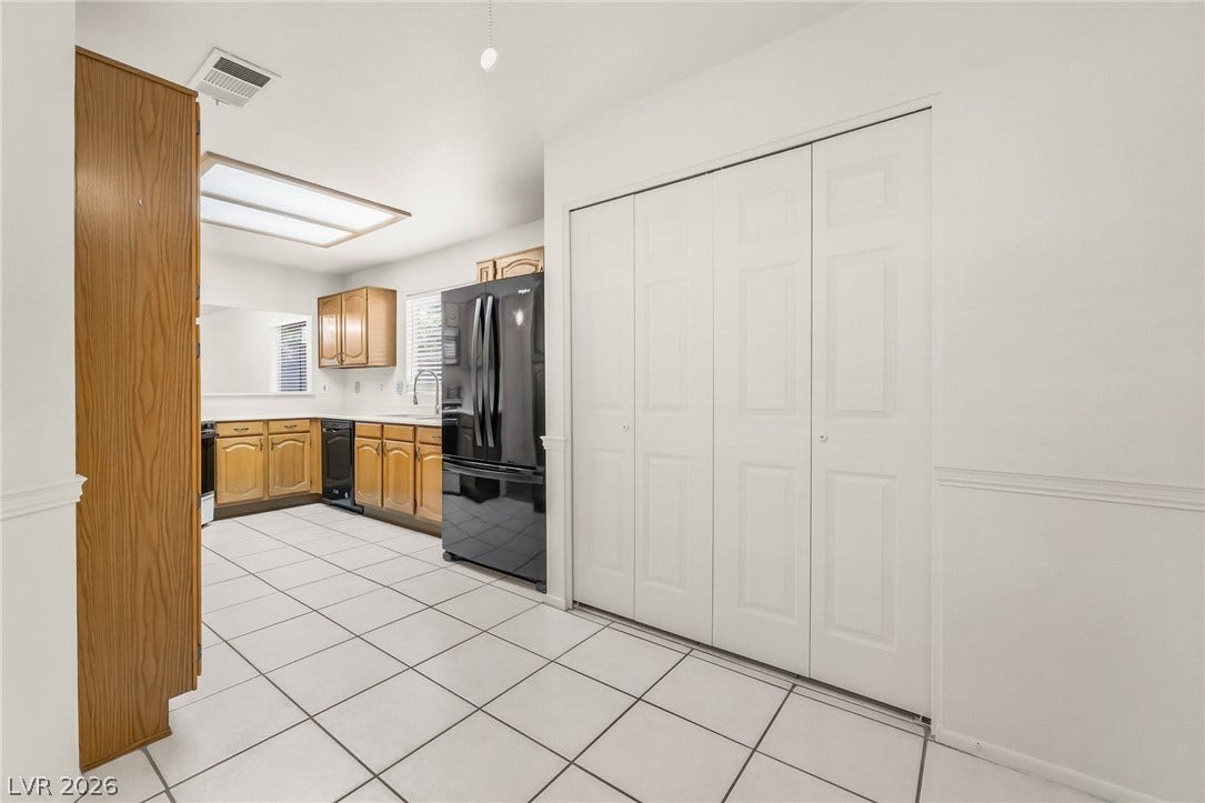 62 Tidwell Lane, Henderson, NV 89074 Tiled flooring runs throughout this practical kitchen space featuring classic wood cabinetry and integrated storage closets.