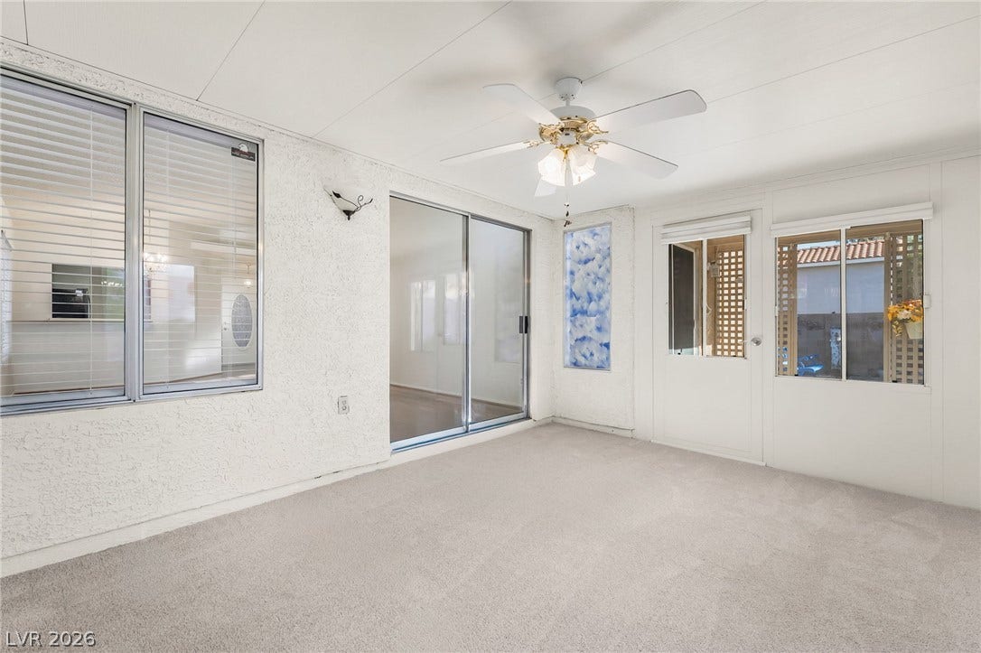 62 Tidwell Lane, Henderson, NV 89074 A spacious sunroom features wall-to-wall carpeting and multiple glass doors leading to the interior.