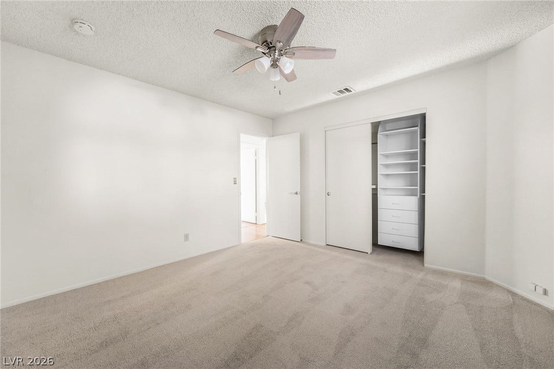 62 Tidwell Lane, Henderson, NV 89074 An airy bedroom highlights plush carpeting and a spacious closet with built-in shelving.