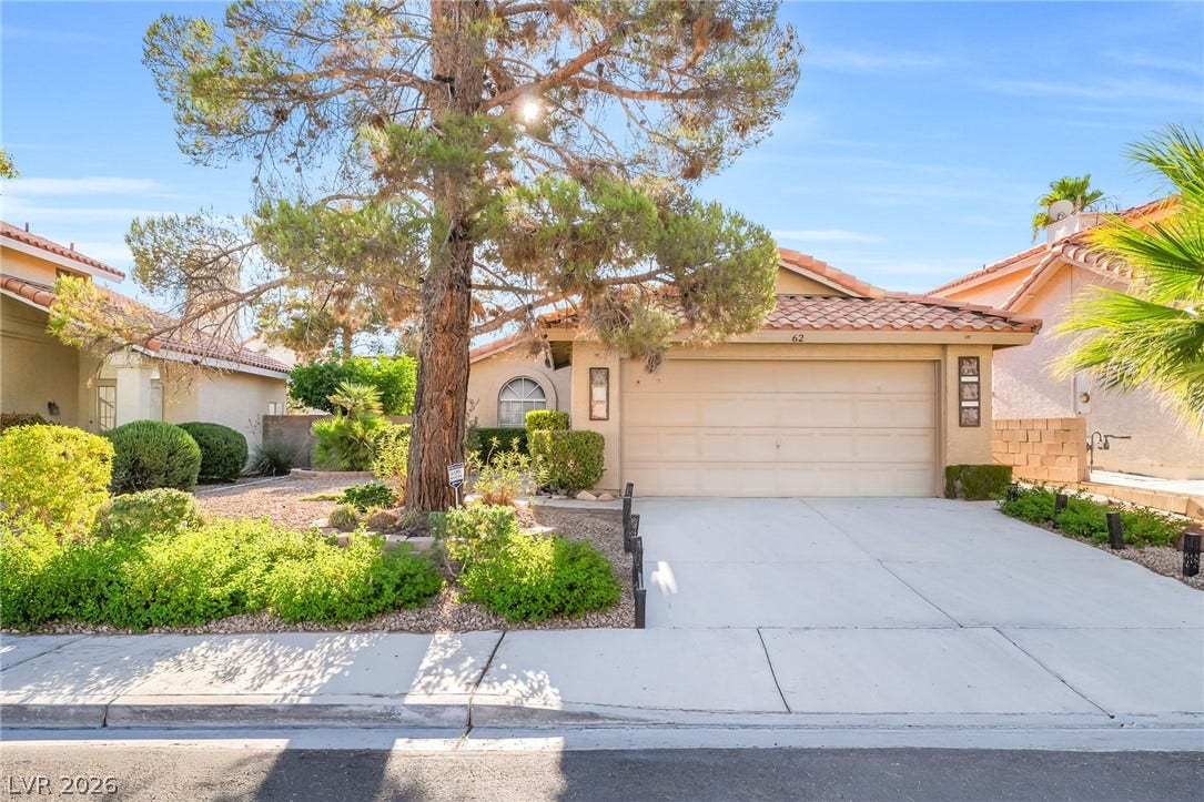 62 Tidwell Lane, Henderson, NV 89074 Spanish tile roofing and a concrete driveway lead to the attached garage entry.