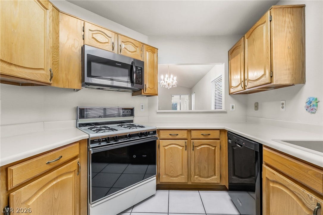 62 Tidwell Lane, Henderson, NV 89074 Honey oak cabinetry pairs with white countertops and tile flooring in this functional layout.