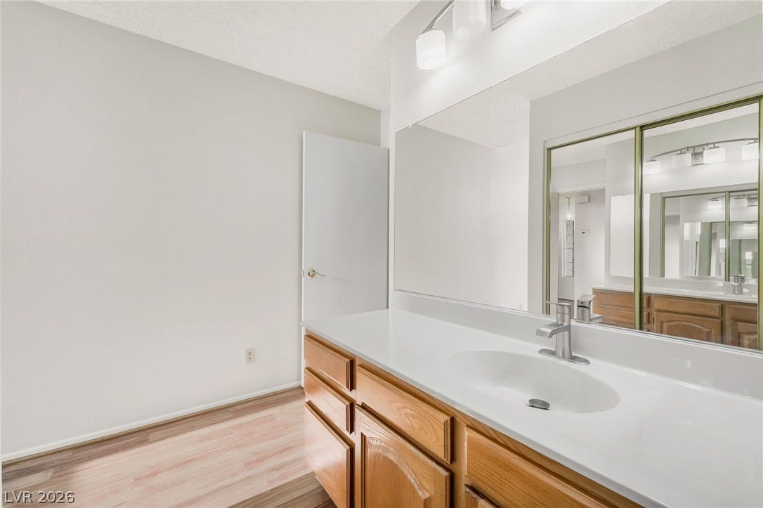 62 Tidwell Lane, Henderson, NV 89074 Warm wood cabinetry pairs with a clean white countertop and smooth wood-look flooring.