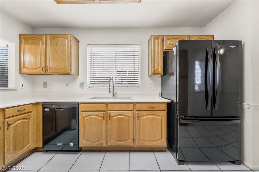 62 Tidwell Lane, Henderson, NV 89074 Warm oak cabinetry pairs with clean countertops and tiled flooring in this classic kitchen.
