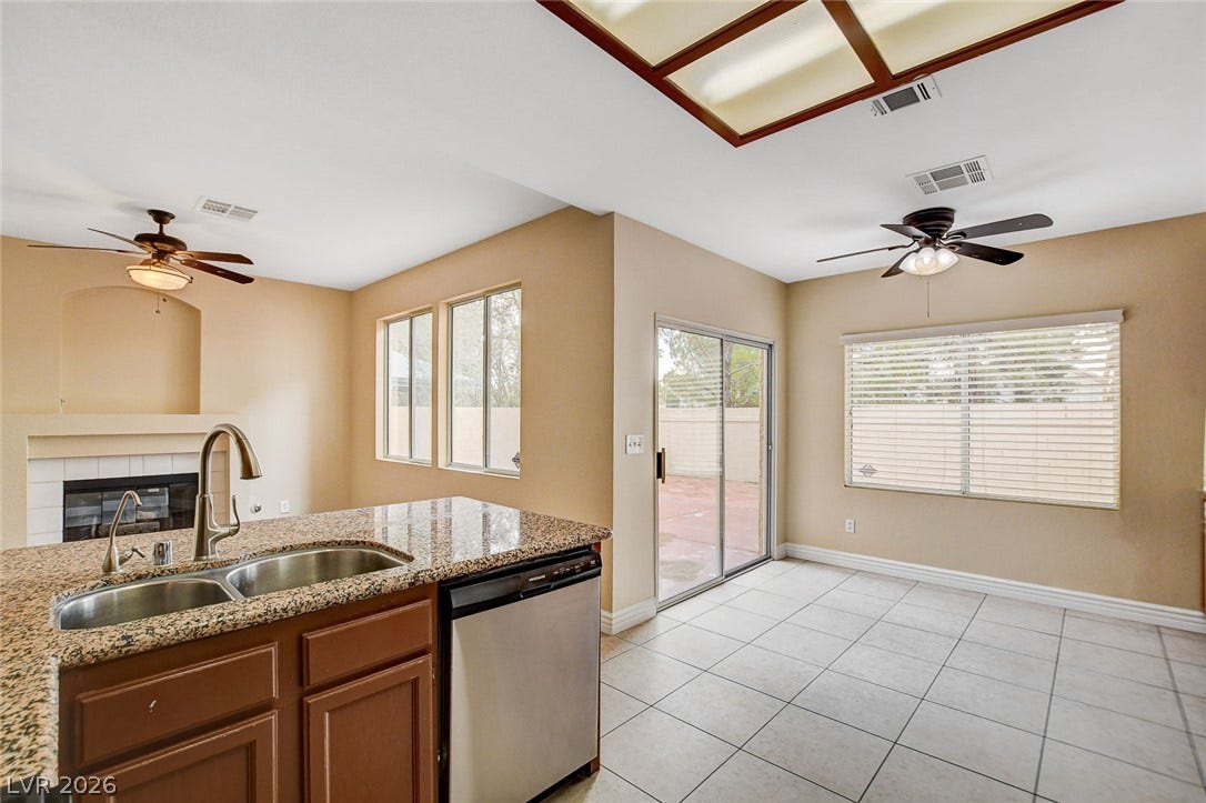 1612 Country Hollow Drive, Las Vegas, NV 89117 A well-appointed kitchen island with granite counters anchors this inviting space, featuring a seamless flow to the dining area and outdoor patio.