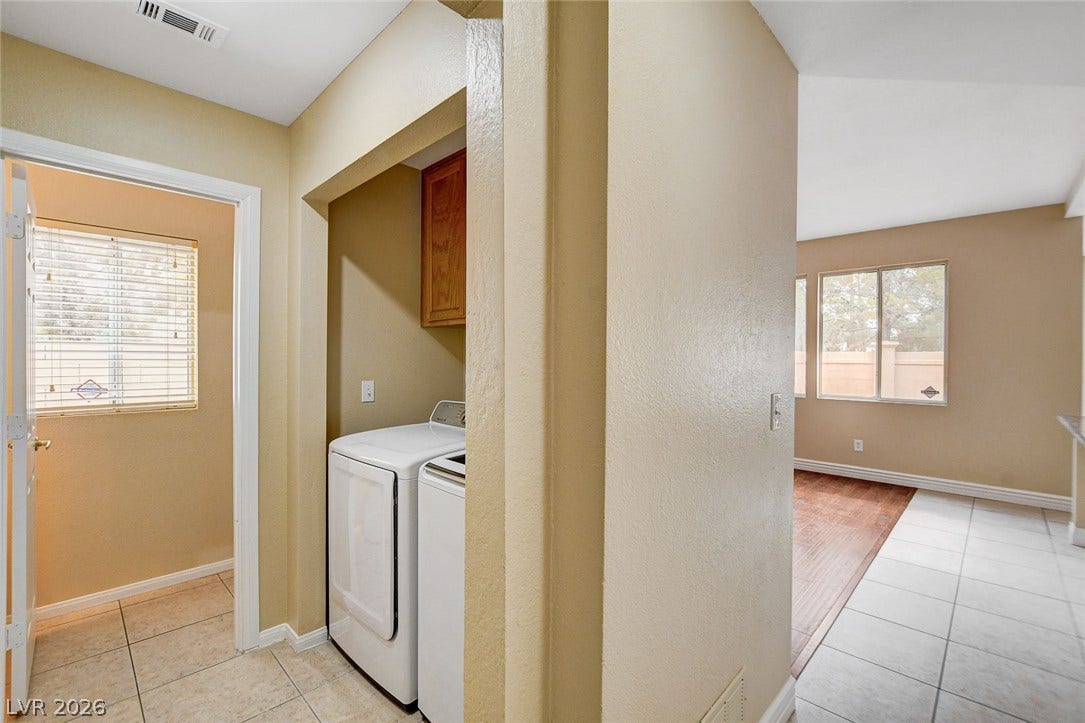 1612 Country Hollow Drive, Las Vegas, NV 89117 Functional laundry area featuring modern appliances and convenient overhead cabinetry, seamlessly connected to living spaces.