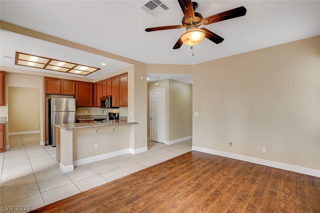 1612 Country Hollow Drive, Las Vegas, NV 89117 An open concept living area features rich wood flooring transitioning to tiled kitchen space.