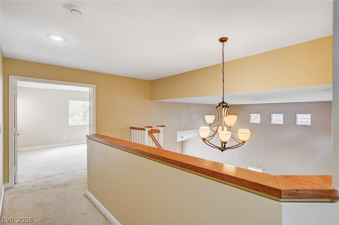 1612 Country Hollow Drive, Las Vegas, NV 89117 An open loft area with a classic chandelier creates an inviting transition between spaces.