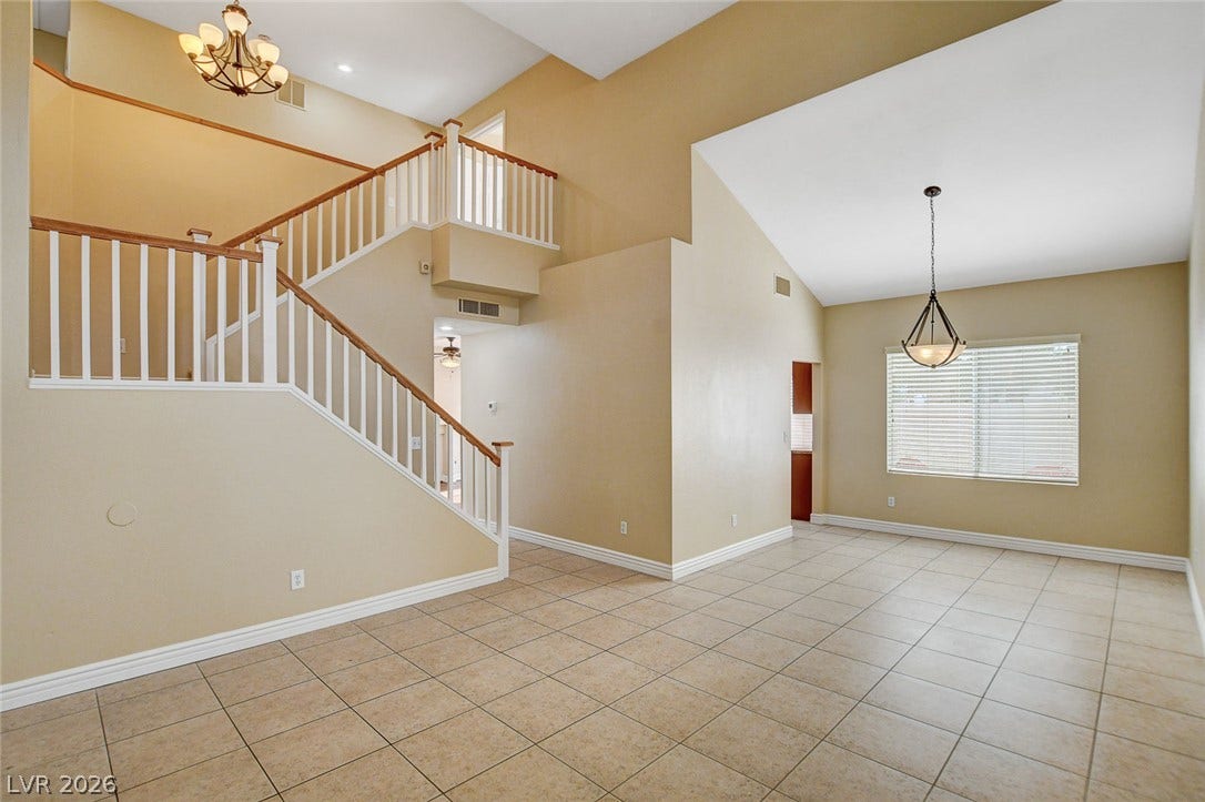 1612 Country Hollow Drive, Las Vegas, NV 89117 A grand entry features a prominent staircase, soaring vaulted ceilings, and durable tile flooring.