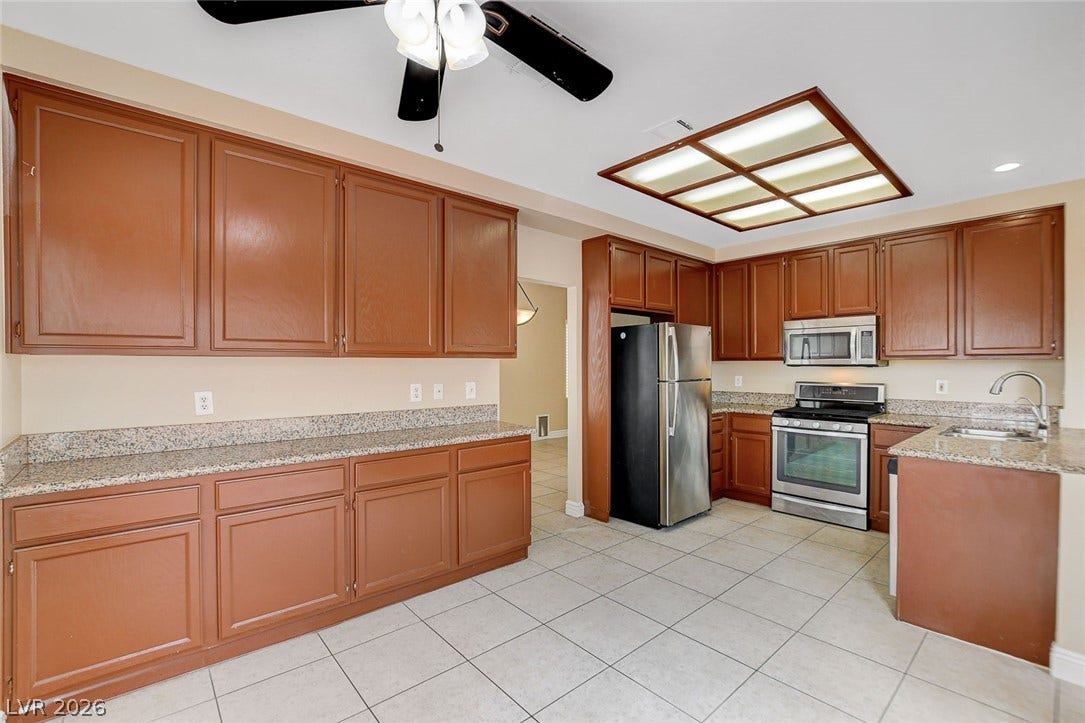 1612 Country Hollow Drive, Las Vegas, NV 89117 A well-appointed kitchen features ample cabinetry, granite counters, and modern stainless steel appliances.