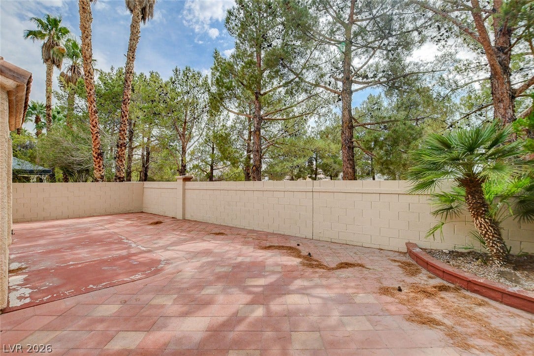 1612 Country Hollow Drive, Las Vegas, NV 89117 A spacious brick patio bordered by a privacy wall, offering a serene outdoor retreat.