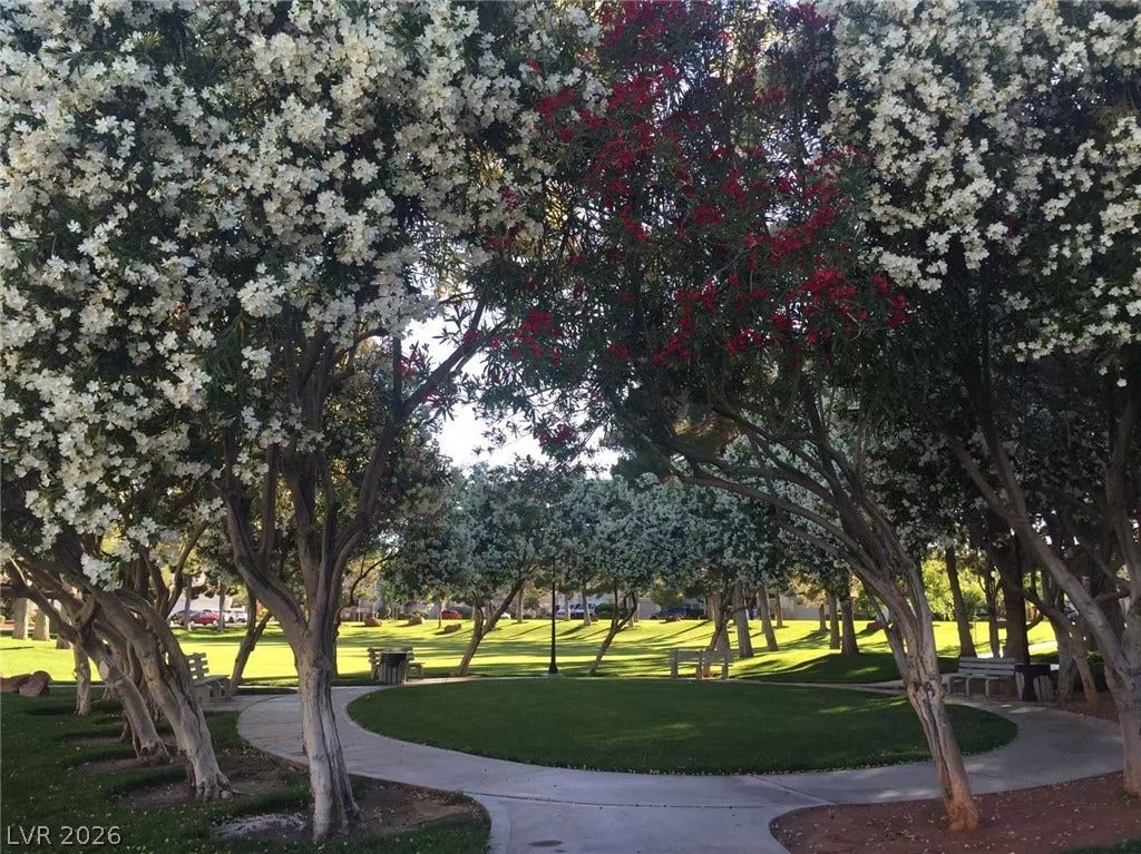 1612 Country Hollow Drive, Las Vegas, NV 89117 Manicured lawns and paved pathways wind through blooming trees in a parklike setting.