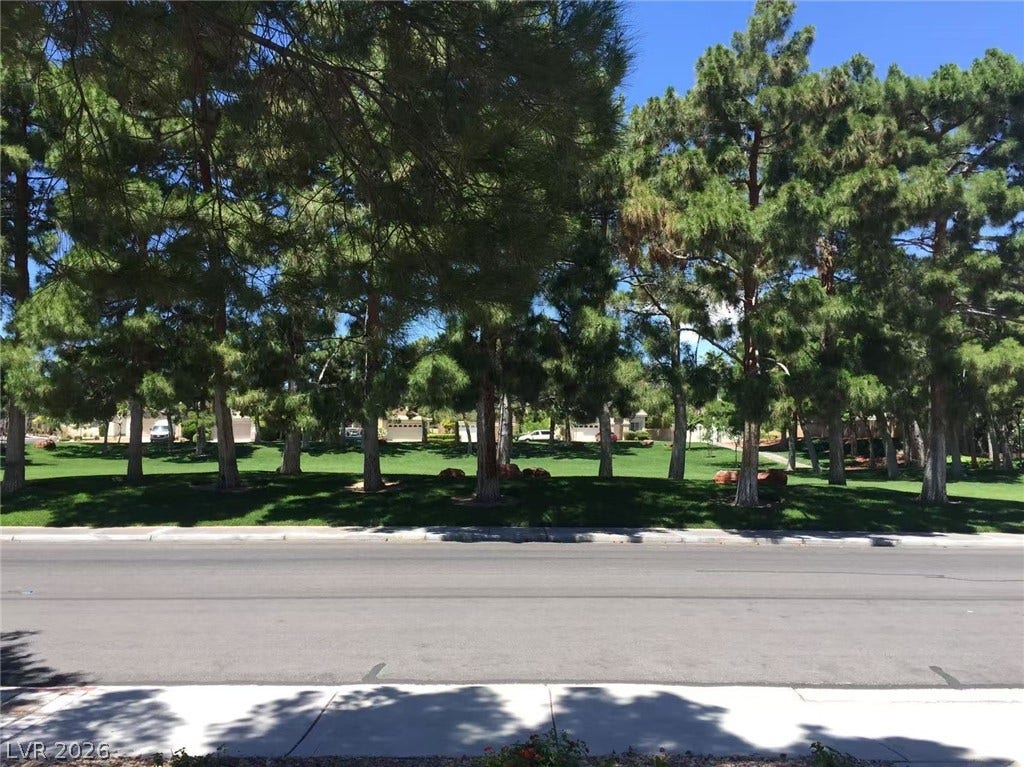 1612 Country Hollow Drive, Las Vegas, NV 89117 Mature trees frame a manicured green space bordering a quiet suburban street.