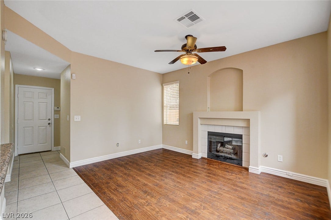 1612 Country Hollow Drive, Las Vegas, NV 89117 A well-lit living area showcases a fireplace with an arched niche and a welcoming front door entry.