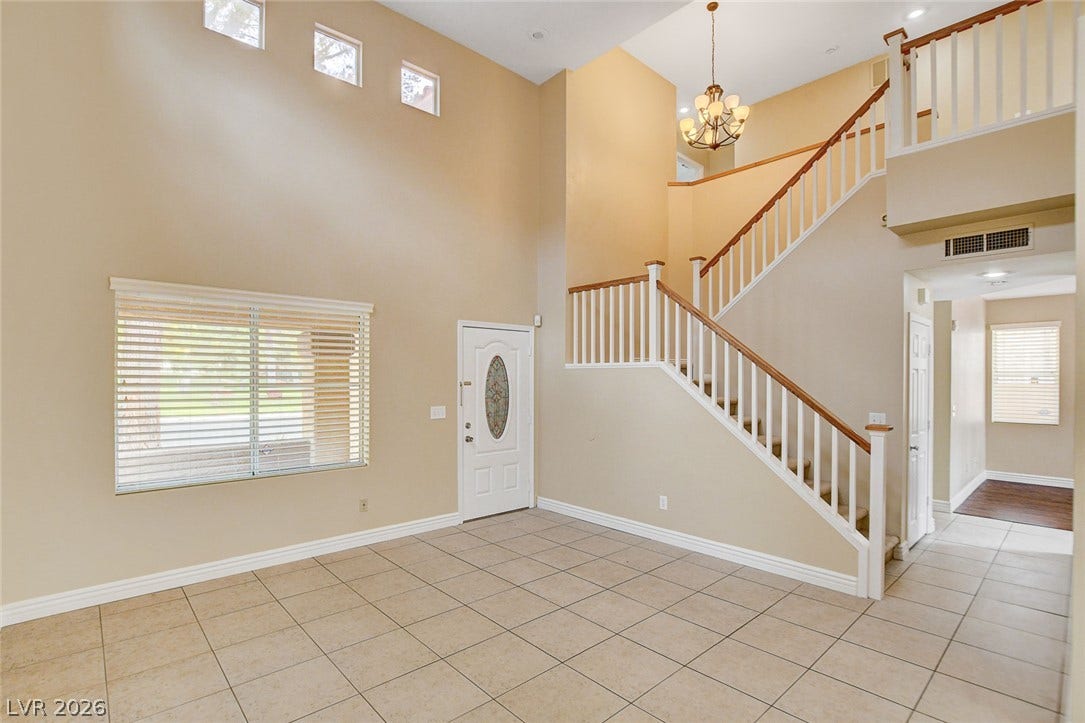 1612 Country Hollow Drive, Las Vegas, NV 89117 Step into a luminous entryway featuring soaring ceilings, elegant tile flooring, and a grand staircase.