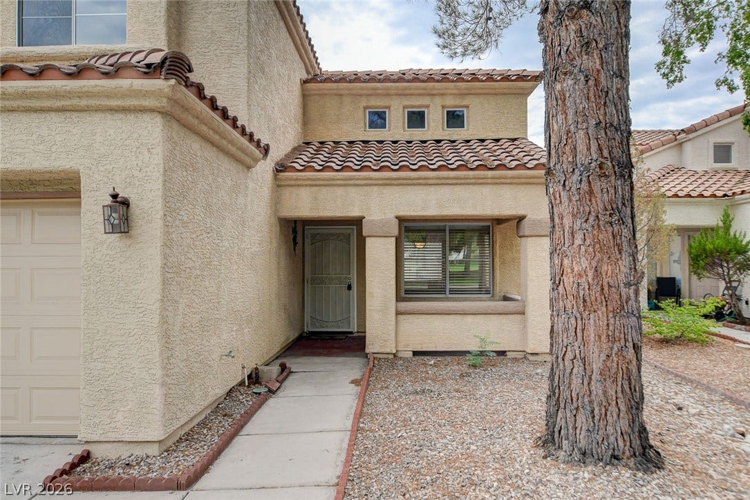 1612 Country Hollow Drive, Las Vegas, NV 89117 A terracotta-tiled roof crowns this charming facade with a well-lit entry and a convenient garage.