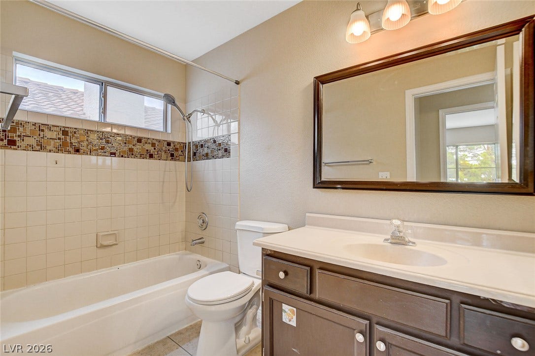 1612 Country Hollow Drive, Las Vegas, NV 89117 A well-appointed bathroom features a bathtub and an elegant vanity with a large mirror.