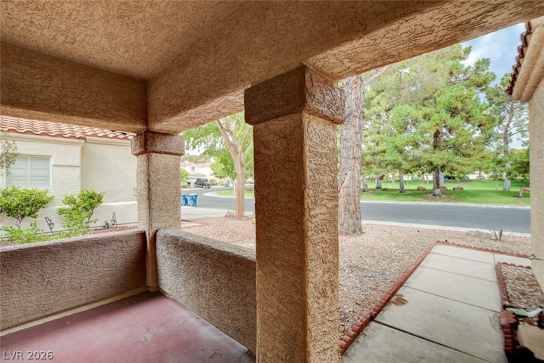 1612 Country Hollow Drive, Las Vegas, NV 89117 A welcoming covered porch with textured columns offers views of mature trees and a manicured streetscape.