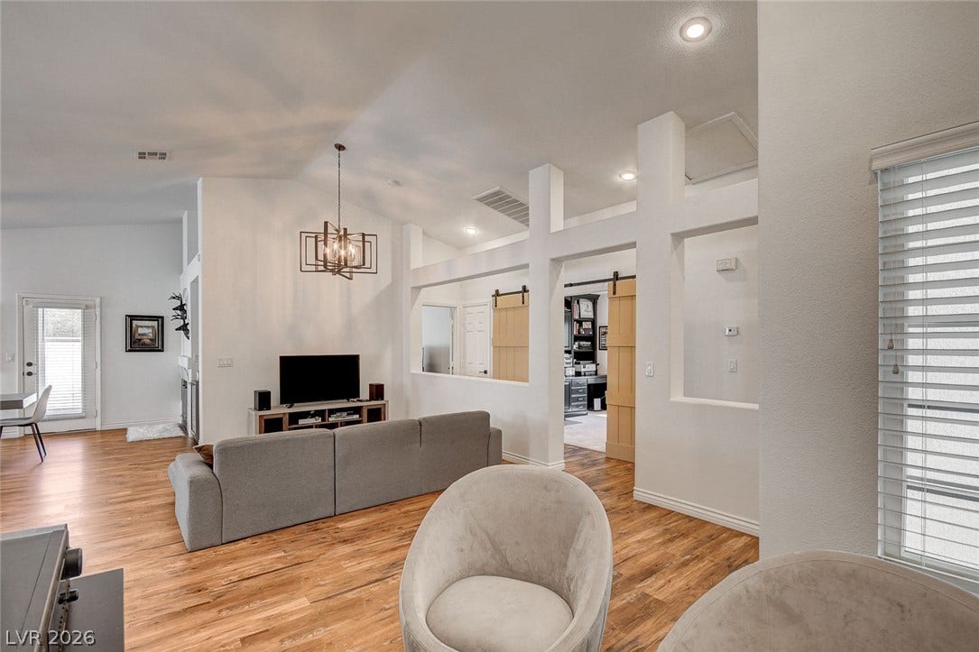 236 Misty Garden Street, Henderson, NV 89012 Warm wood-look flooring and custom architectural cutouts define this inviting open living space.