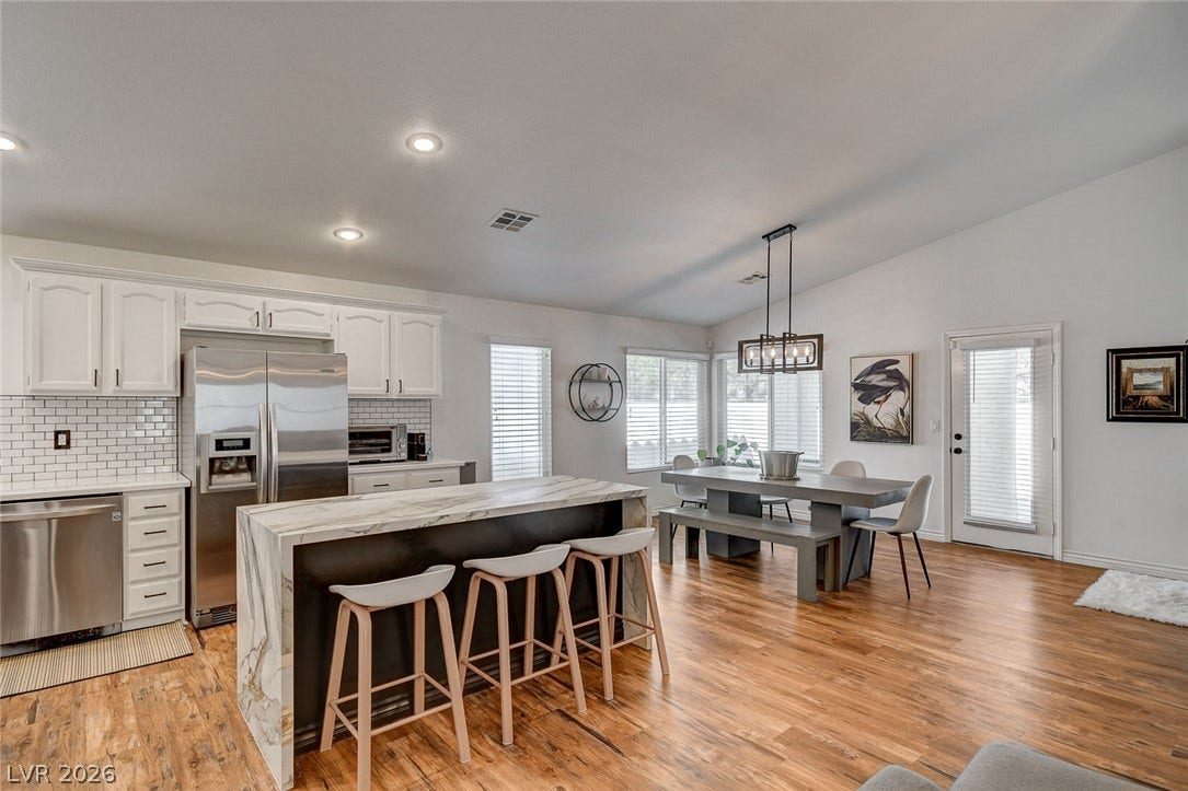 236 Misty Garden Street, Henderson, NV 89012 Polished hardwood flooring anchors this open kitchen and dining area under tall ceilings.