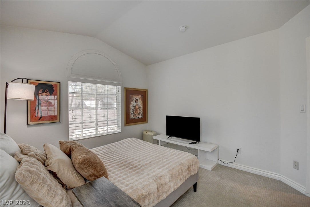 236 Misty Garden Street, Henderson, NV 89012 Vaulted ceilings and a large arched window design define this bedroom space.