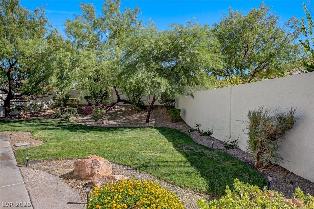 236 Misty Garden Street, Henderson, NV 89012 Mature trees and neat lawns frame a secure, walled backyard perfect for outdoor relaxation.