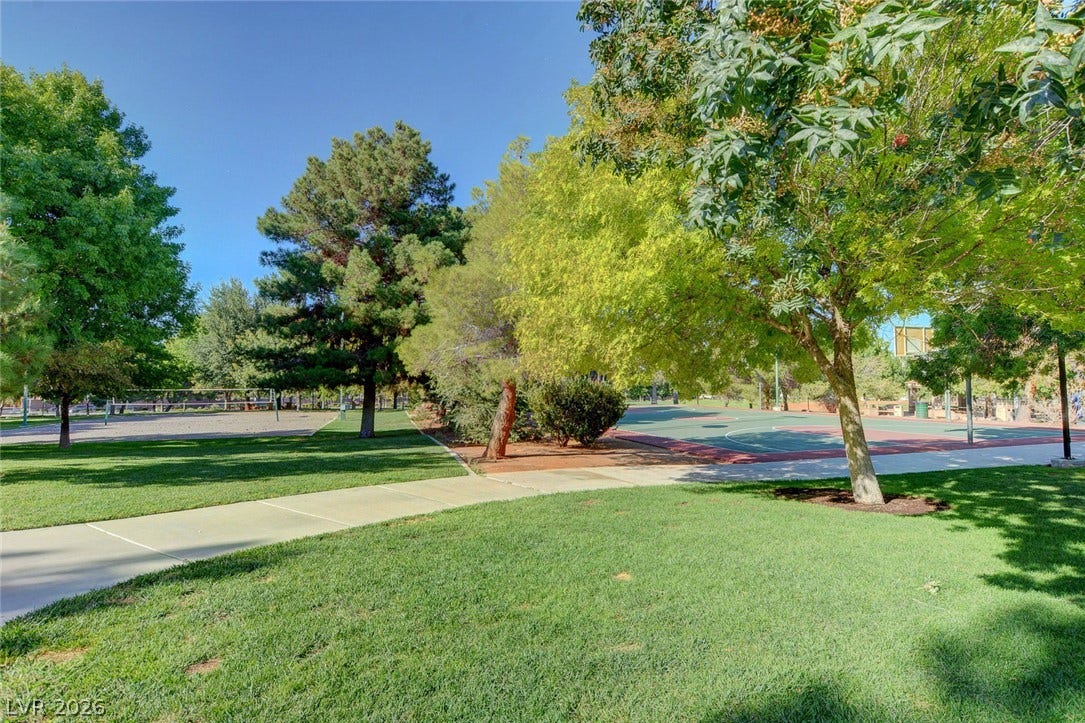 236 Misty Garden Street, Henderson, NV 89012 Mature trees shade the manicured lawns bordering paved walkways and community sports courts.