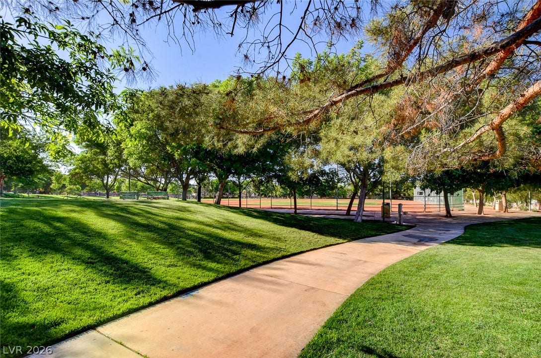 236 Misty Garden Street, Henderson, NV 89012 A winding paved walkway meanders through manicured lawns and mature trees near the community park.