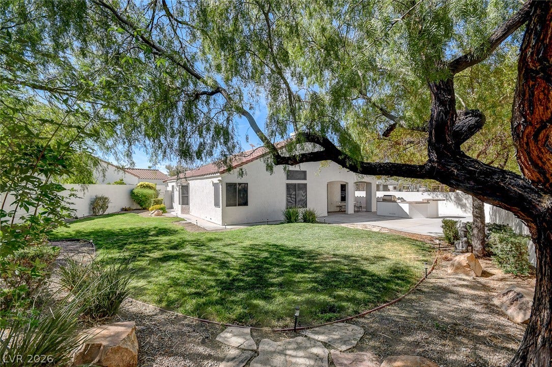 236 Misty Garden Street, Henderson, NV 89012 Mature trees shade a manicured lawn leading to the rear patio and outdoor kitchen.