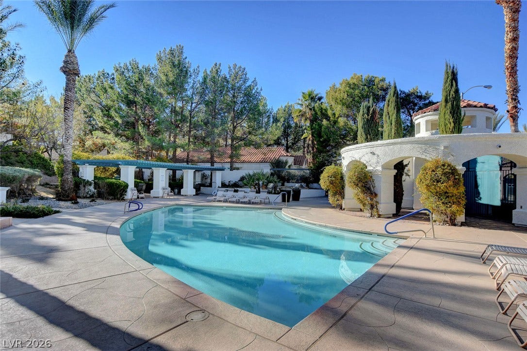 236 Misty Garden Street, Henderson, NV 89012 Manicured landscaping surrounds a pristine pool area complete with paved sun decks and architectural arches.