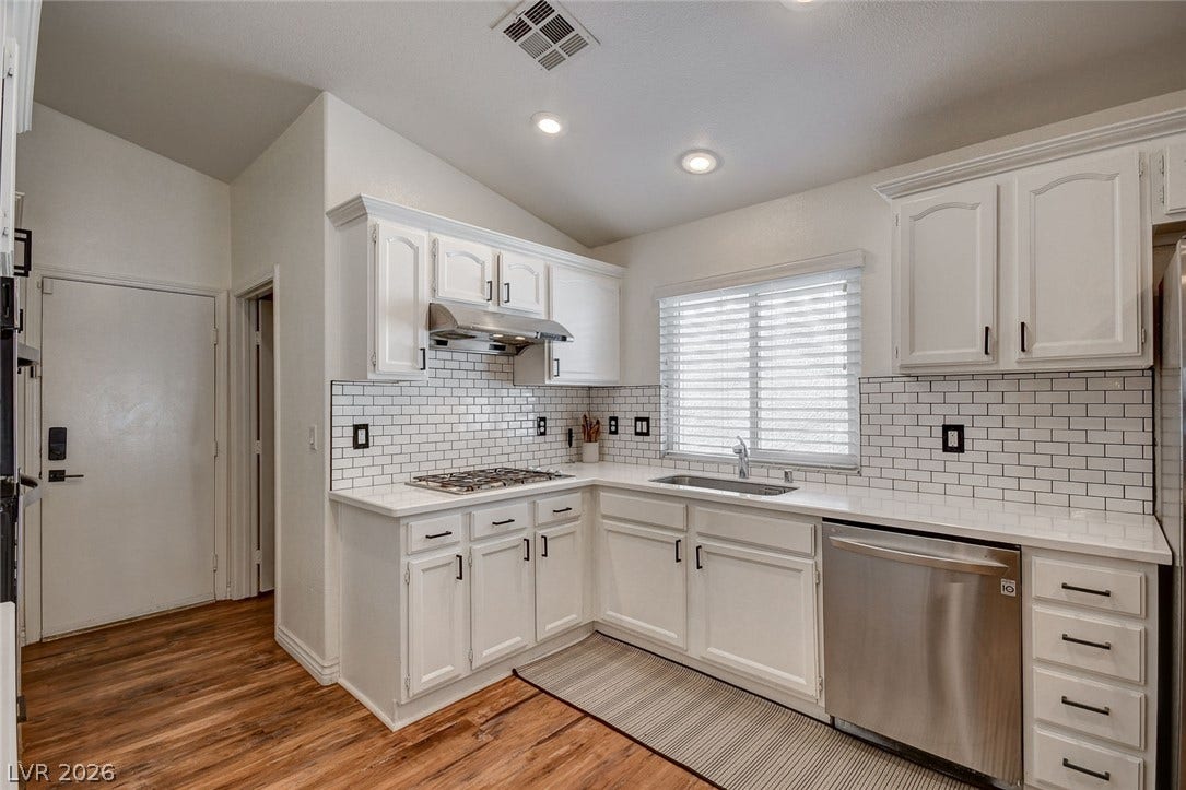 236 Misty Garden Street, Henderson, NV 89012 Gleaming stone countertops and classic subway tile backsplash accent this light-filled culinary space.