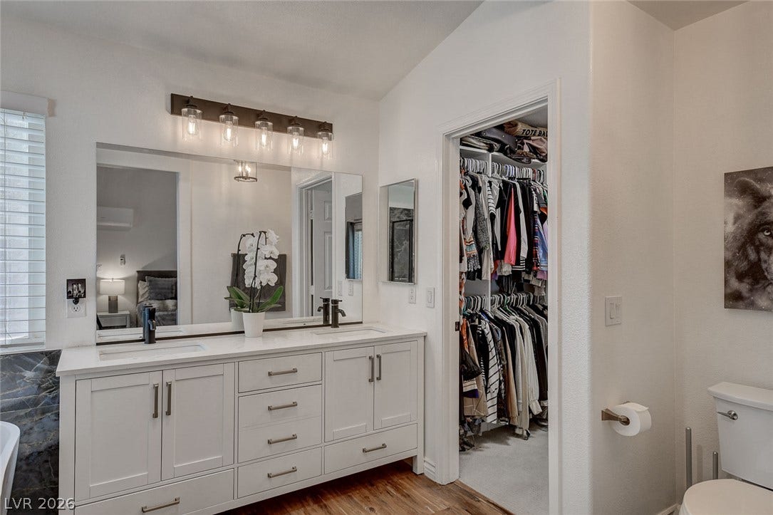 236 Misty Garden Street, Henderson, NV 89012 Double vanities sit on rich wood flooring, leading directly into a spacious walk-in closet.