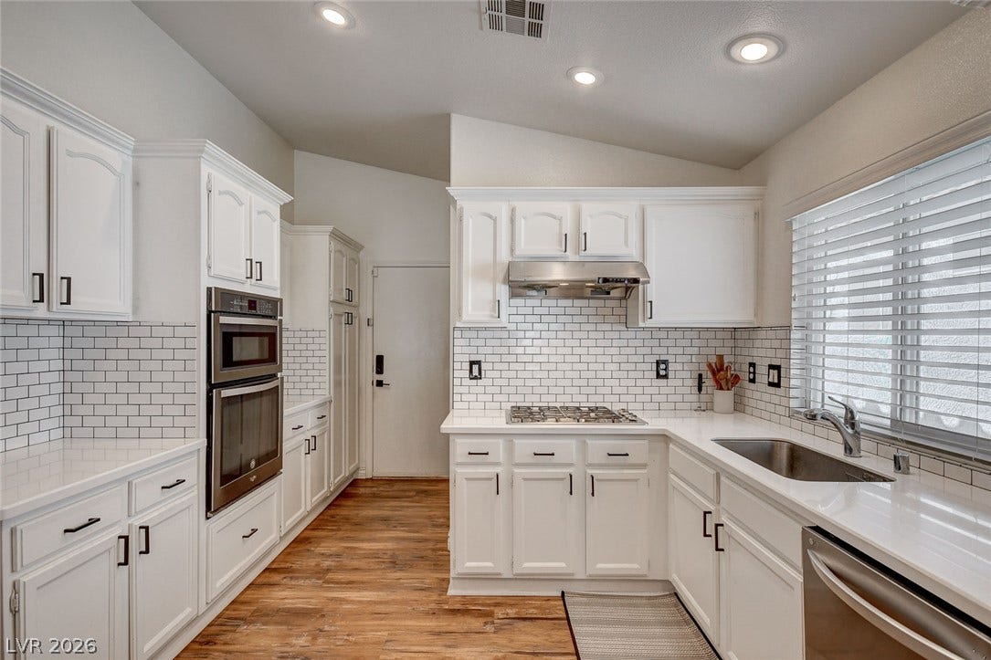 236 Misty Garden Street, Henderson, NV 89012 Crisp white cabinetry and tile backsplashes coordinate beautifully with rich hardwood flooring.