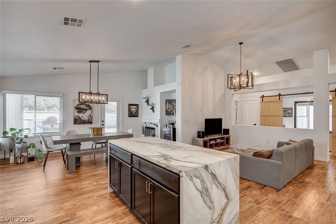236 Misty Garden Street, Henderson, NV 89012 Rich hardwood flooring anchors this open floorplan seamlessly connecting the kitchen and living areas.