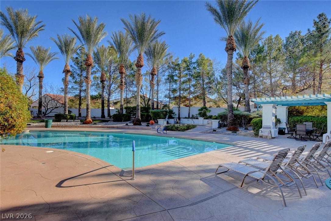 236 Misty Garden Street, Henderson, NV 89012 Soaring palm trees and a concrete terrace frame this inviting swimming pool.