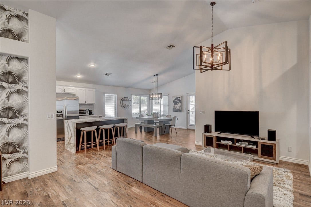 236 Misty Garden Street, Henderson, NV 89012 Vaulted ceilings and warm wood floors span this integrated open-concept living space.